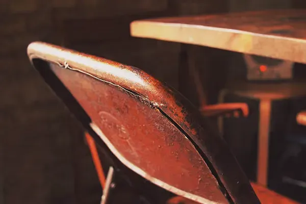 the worn back of a restaurant chair
